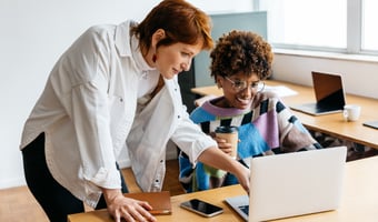 Two colleagues reviewing employment law changes on a laptop in a modern office