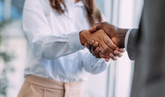 Employee shakes hands with their manager in positive acceptance of voluntary redundancy.
