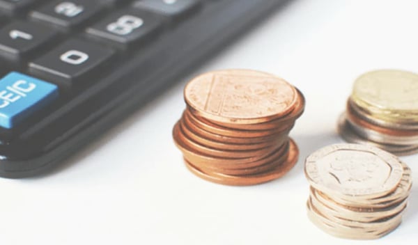 Coins in a pile next to a calculator
