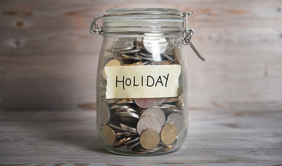 Coins in a glass jar labelled 'holiday'