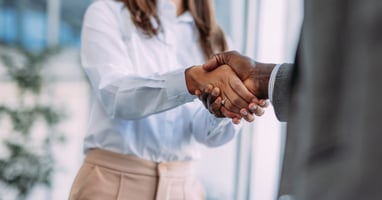 Employee shakes hands with their manager in positive acceptance of voluntary redundancy.