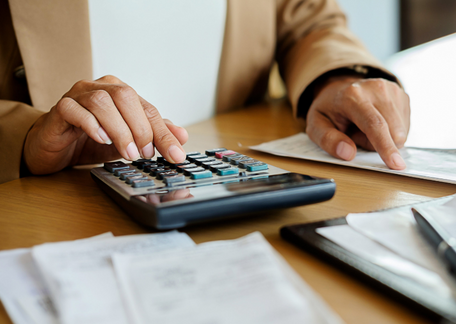Person using a calculator to work out the hourly wage of their staff