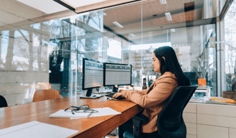 A small business owner working across two monitors displaying spreadsheets, as one of the clearest signs it