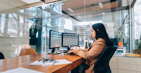 A small business owner working across two monitors displaying spreadsheets, as one of the clearest signs it