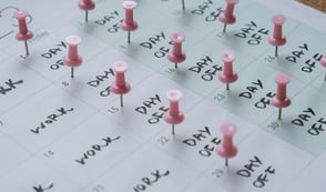 Calendar with work days and days off written in each day - days off have pins in too