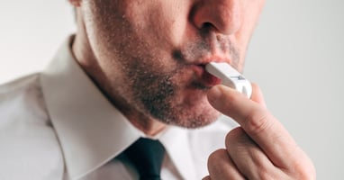 Man in a white shirt and tie blowing a whistle, representing whistleblowing in the workplace