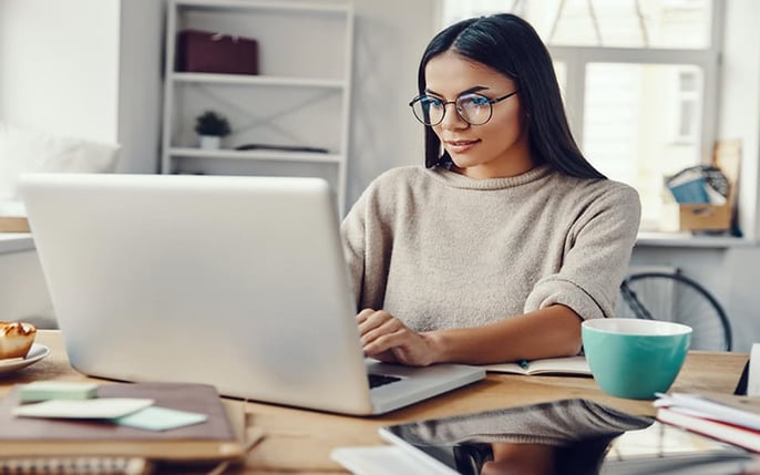 Woman with glasses working on a laptop