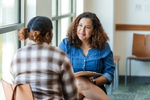 Employee discussing mental health reasonable adjustments with a workplace support professional during a one-to-one meeting in an office. 