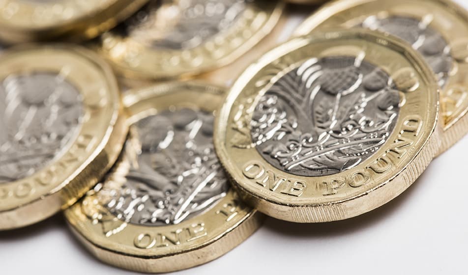 British one pound coins are shown, close up. 