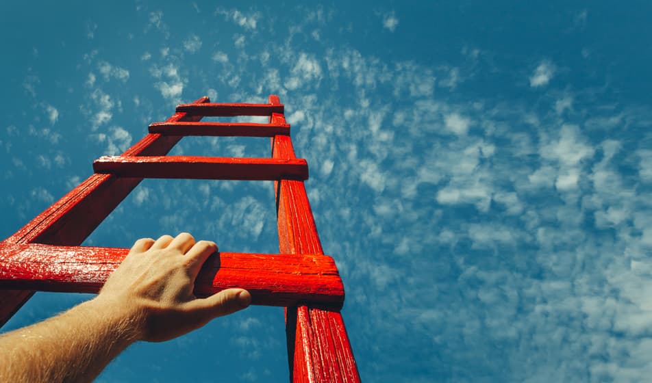 A man is climbing a red ladder which leads into a blue sky.