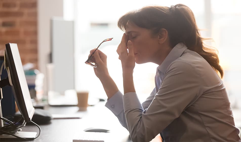 Tired lady rubbing her eyes while holding her glasses