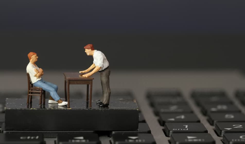 working online concept-miniature businessman boss angry with employee on laptop computer
