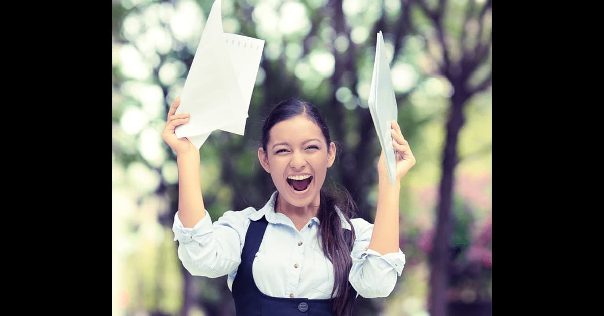 Woman celebrating holding two pieces of paper