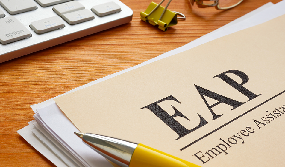 An Employee Assistance Programme form (EAP) is placed on a wooden table with a yellow pen lying on top of it.  