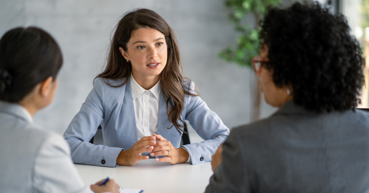 Three workers sat together in a serious conversation during the redundancy consultation period.