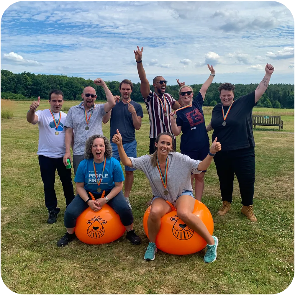 Team Breathe in a field waving their arms in the air for sports day