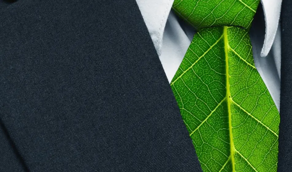 A man is wearing a suit with a green tie made out of leaves.