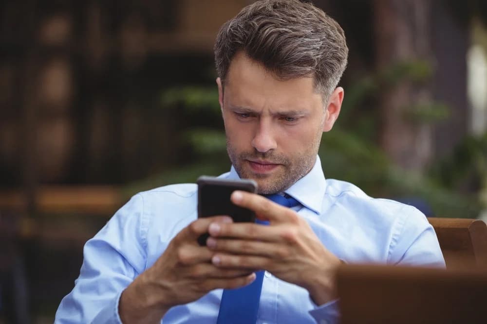 Thoughtful businessman using mobile phone