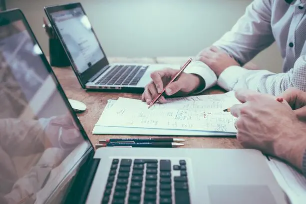 Two employees reviewing notes together