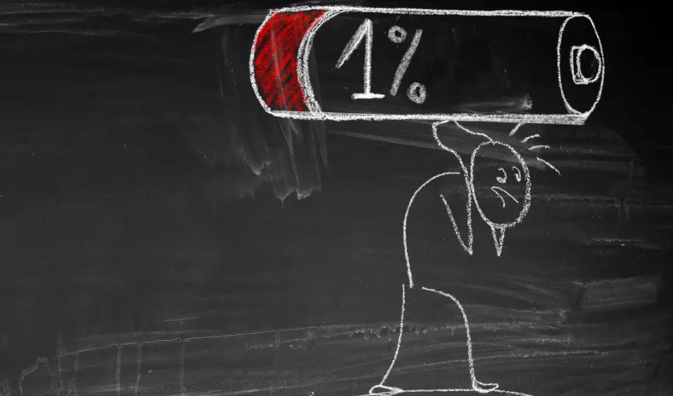 A person drawn in chalk on a slate board, carrying the weight of a big chalk drawn battery showing red and 1%