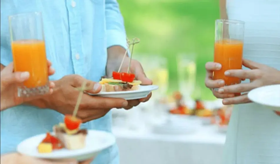 Colleagues are enjoying food and drinks at their latest company event. The company offers events like this within their benefits package.
