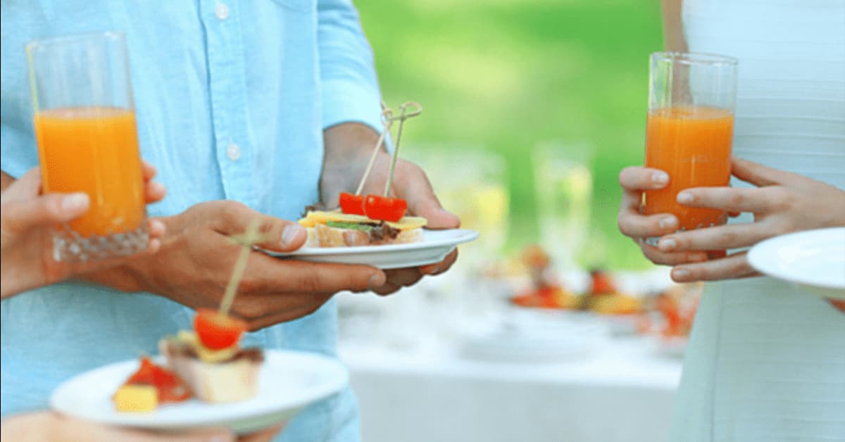 Man holding a plate of food at a summer party