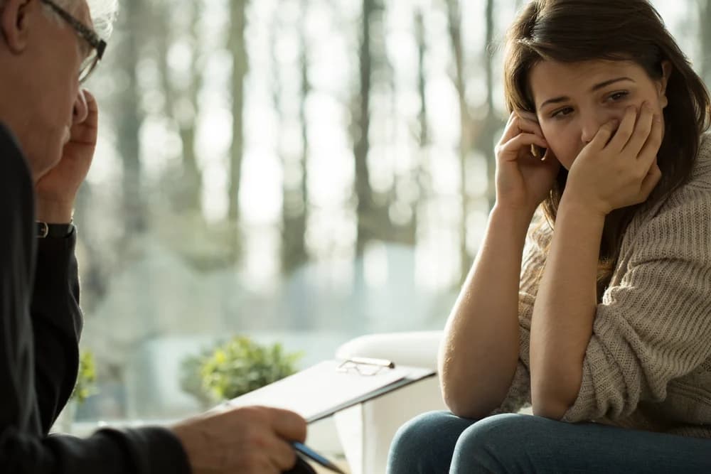 A woman is talking to a psychologist. Her mental health has been declining at work and the company are looking out for employee wellbeing.