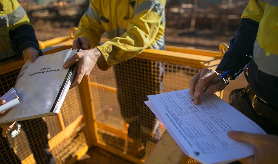 Construction workers handle paperwork & health and safety documents