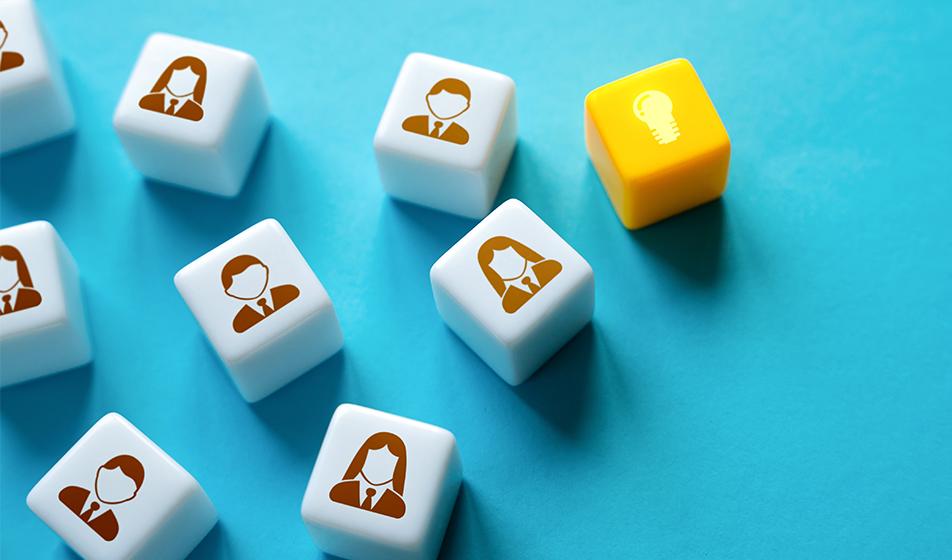 White cubes with people illustrated on them are shown against a blue background. One cube is yellow and shows a lightbulb. 