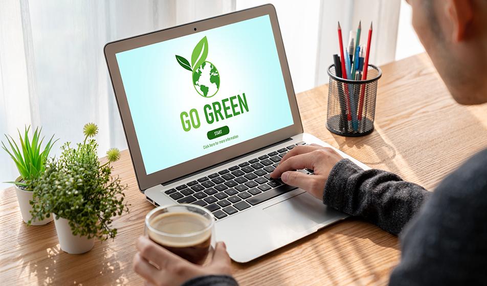 a man working on a laptop with a go green website screen