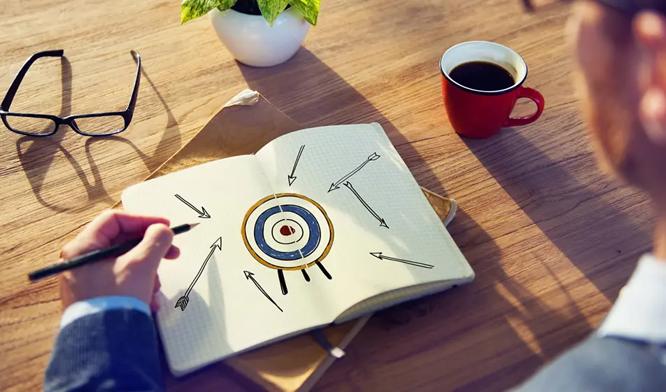man drawing target on a pad with arrows going toward it