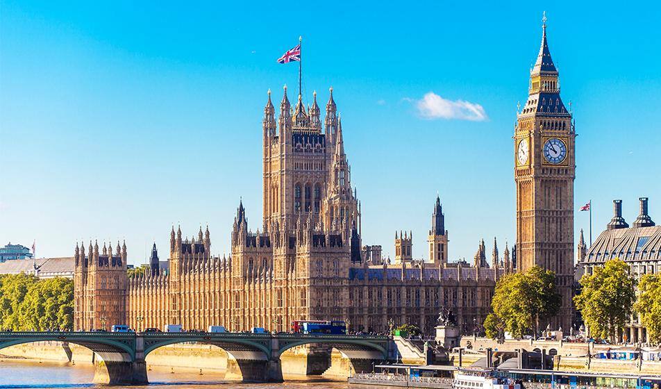 The UK's Houses of Parliament are shown across the river Thames in sunshine