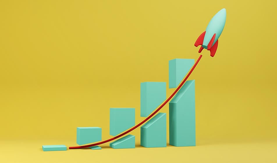 A blue 3D bar chart is shown against a yellow background, indicating increasing results or quantities. A rocket shoots through them all, with a red line trailing behind it in its wake