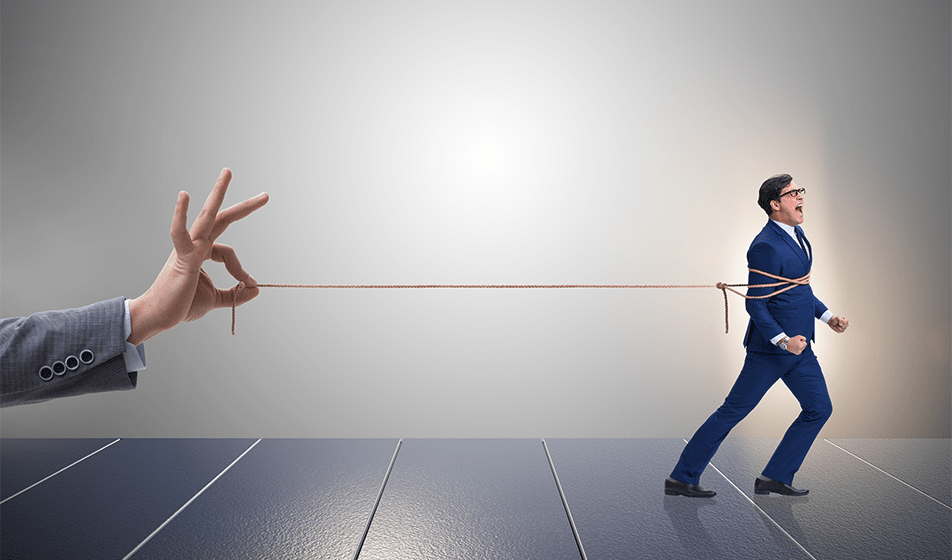 a man in a suit is tied in a piece of string and walking away. A hand, holding the string, is holding him within it