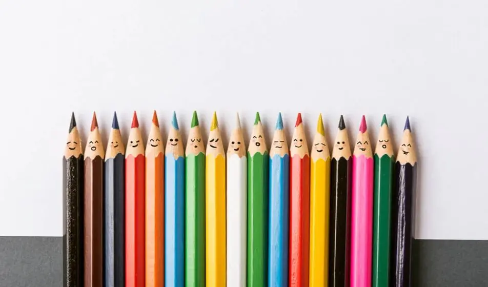 Row of multi-coloured pencils with happy faces