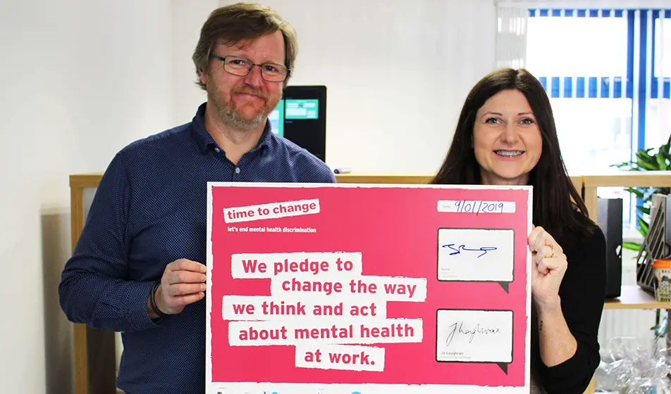 Jonathan Richards and a woman are holding up the "Time to change" signed certificate.